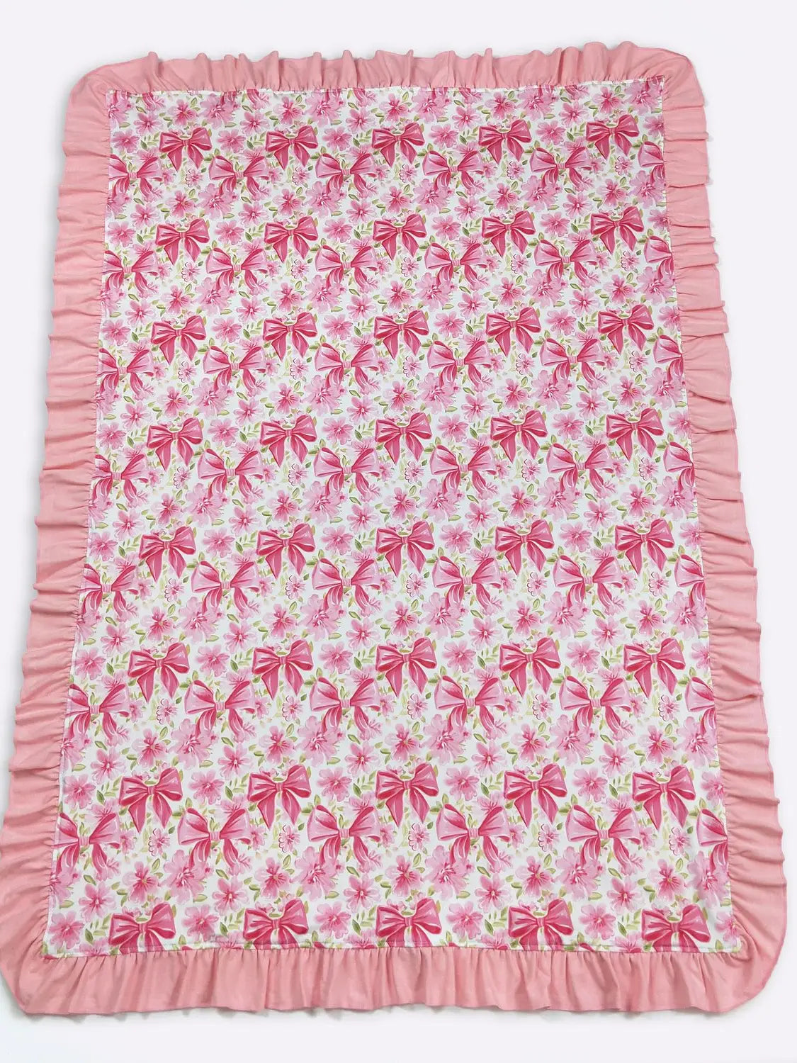 Pink and white blanket with bow pattern on a white background