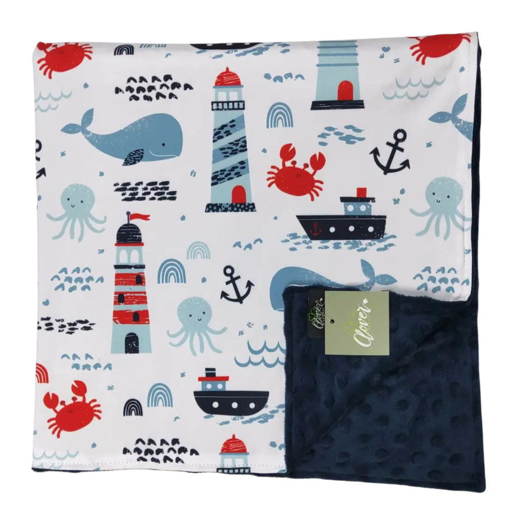 Children's blanket with nautical pattern featuring lighthouses, boats, and sea creatures on a white background.