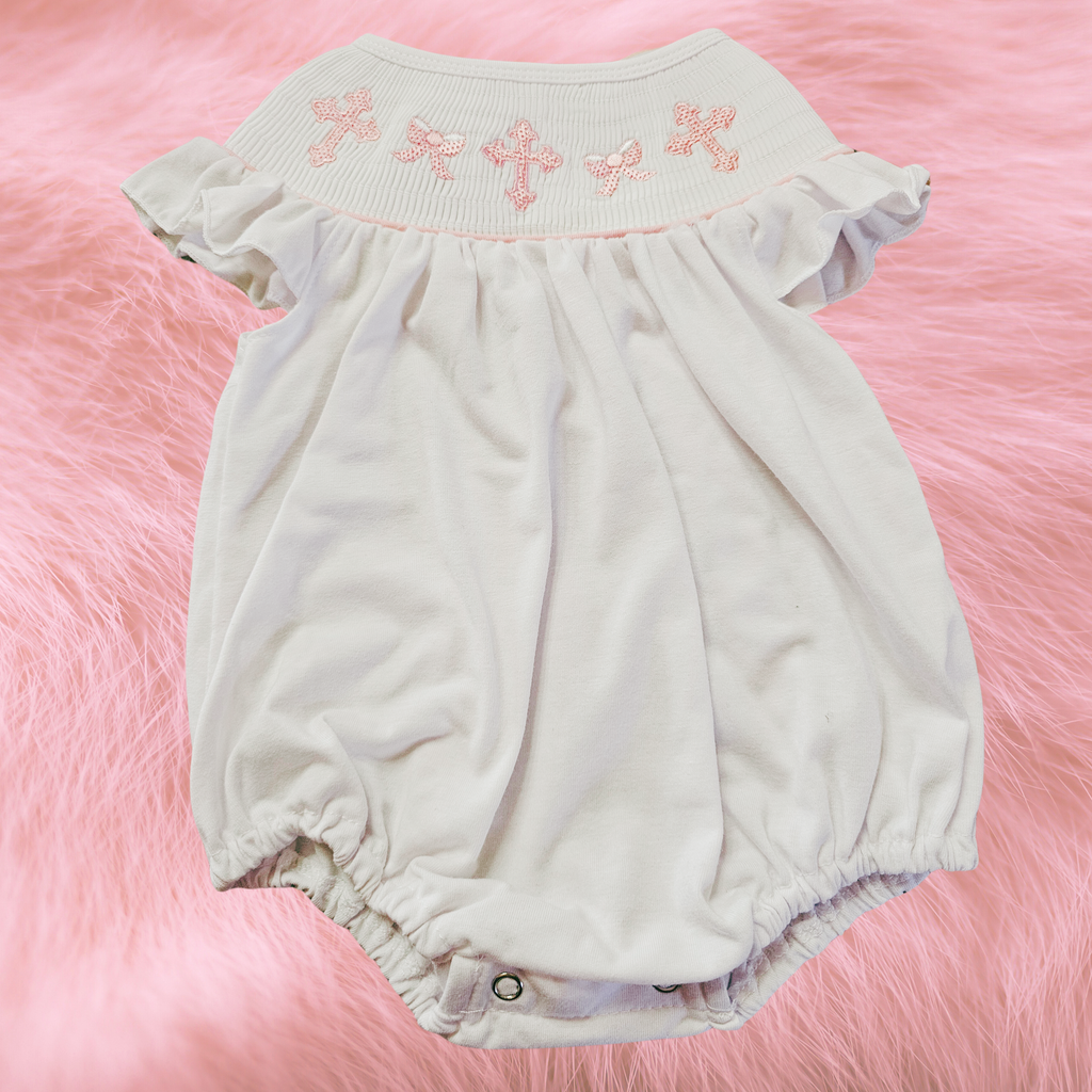 Baby romper with floral embroidery on a pink fluffy background