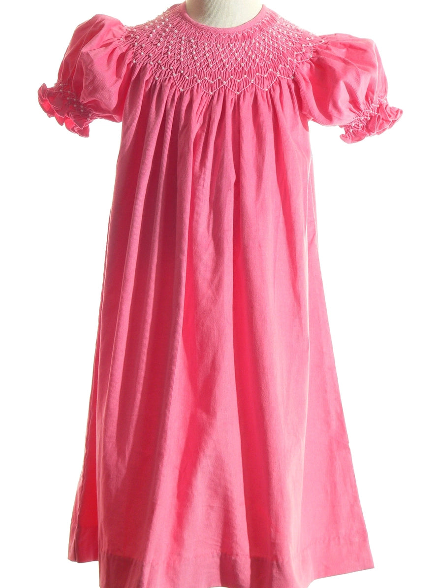 Pink dress with smocked collar on a white background