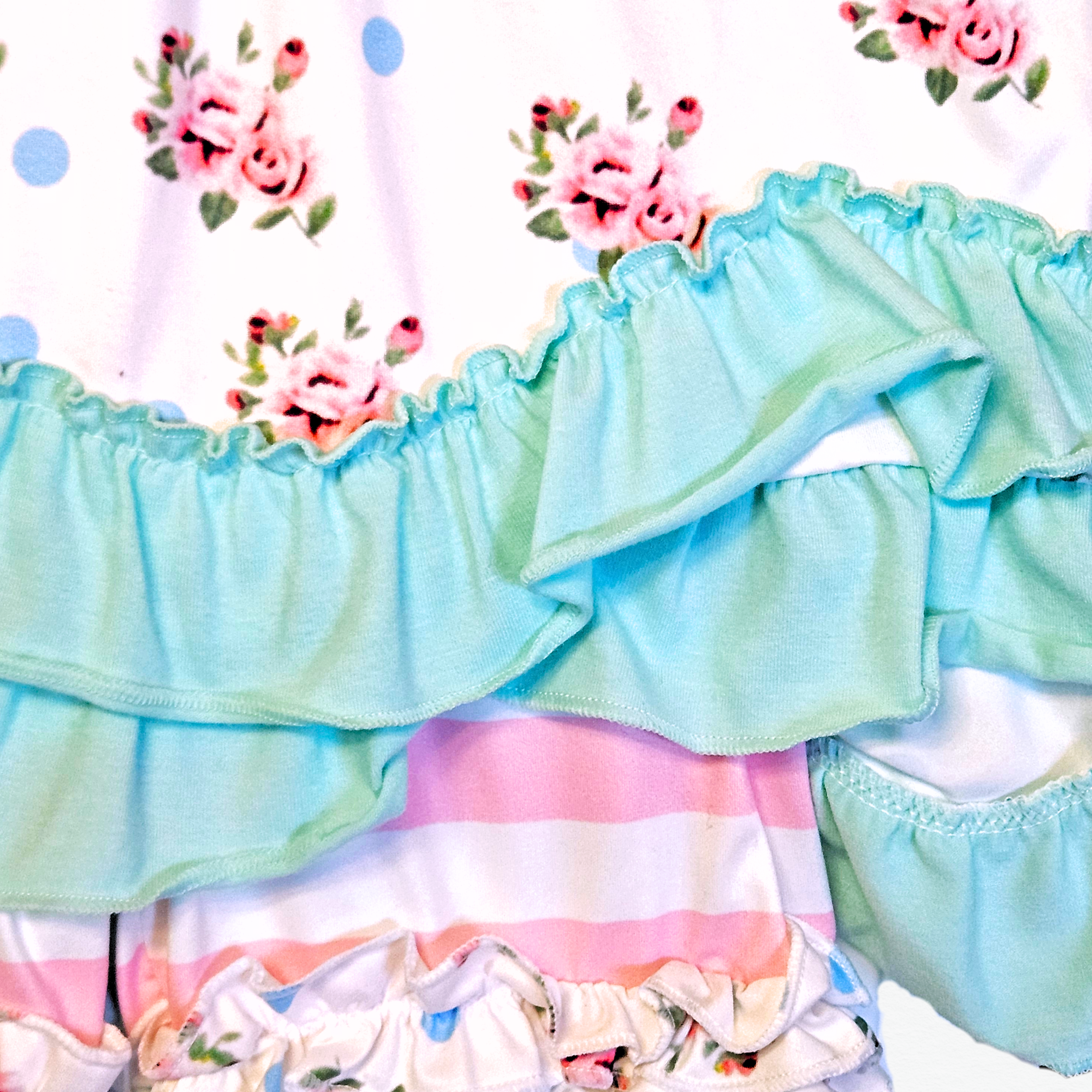 Pastel-colored ruffled fabric with floral patterns on a white background