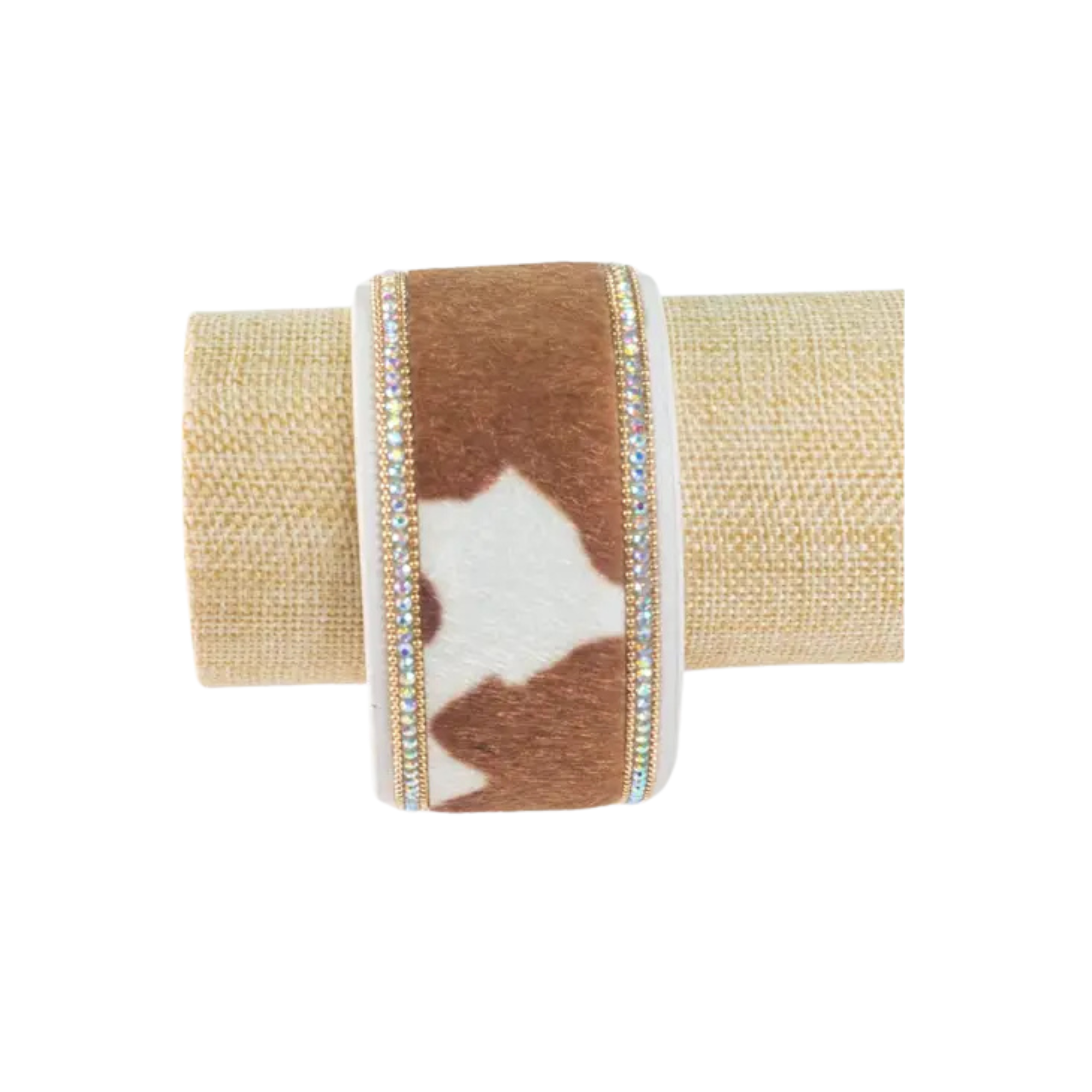 Napkin ring with brown and white cow print design on a beige background