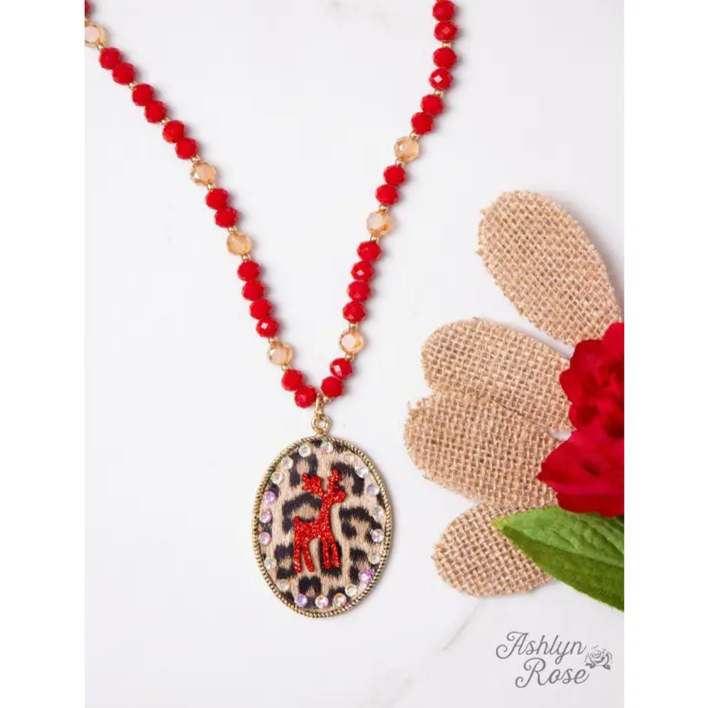 Necklace with red beads and a leopard print pendant on a white background