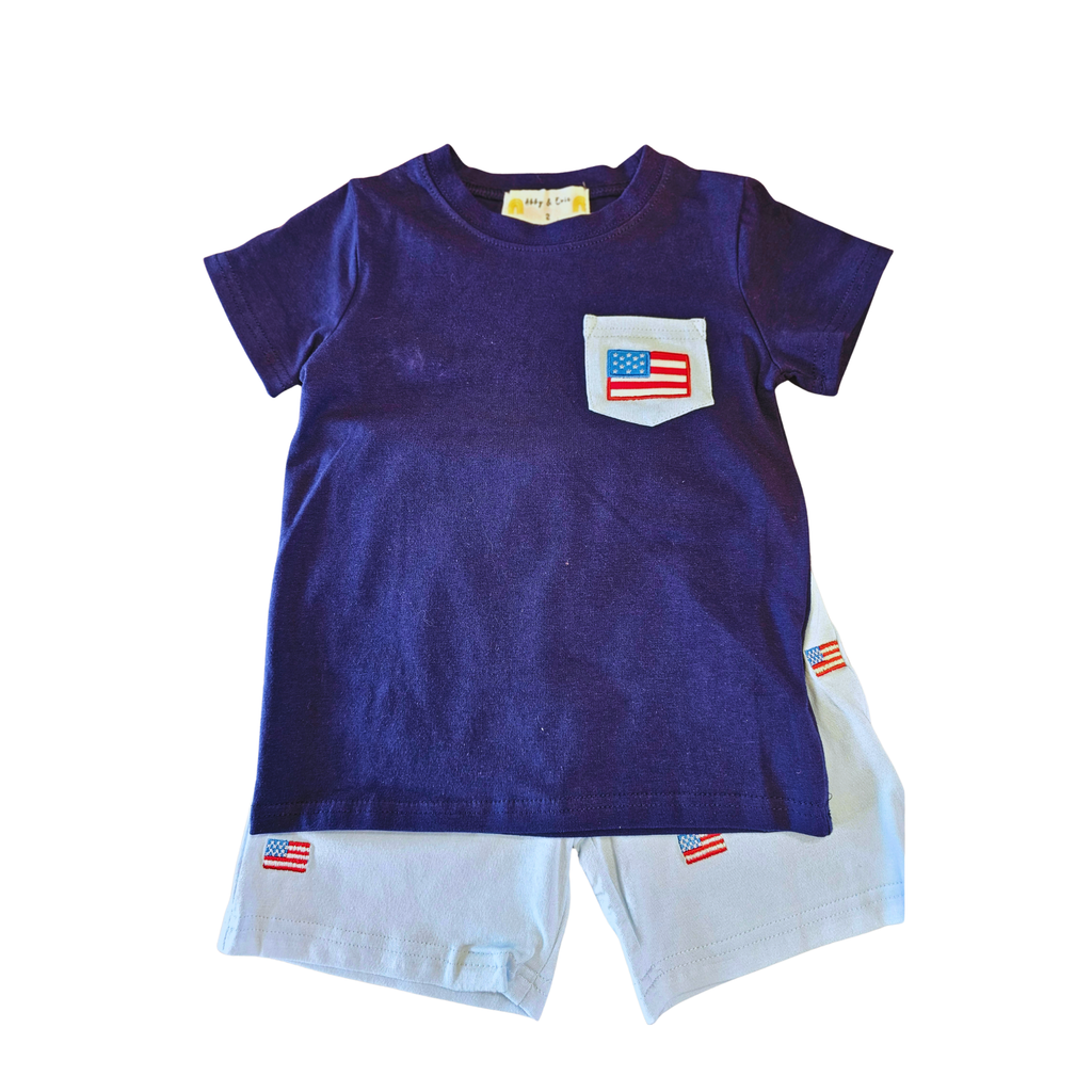 Navy blue t-shirt with an American flag pocket and white shorts on a white background