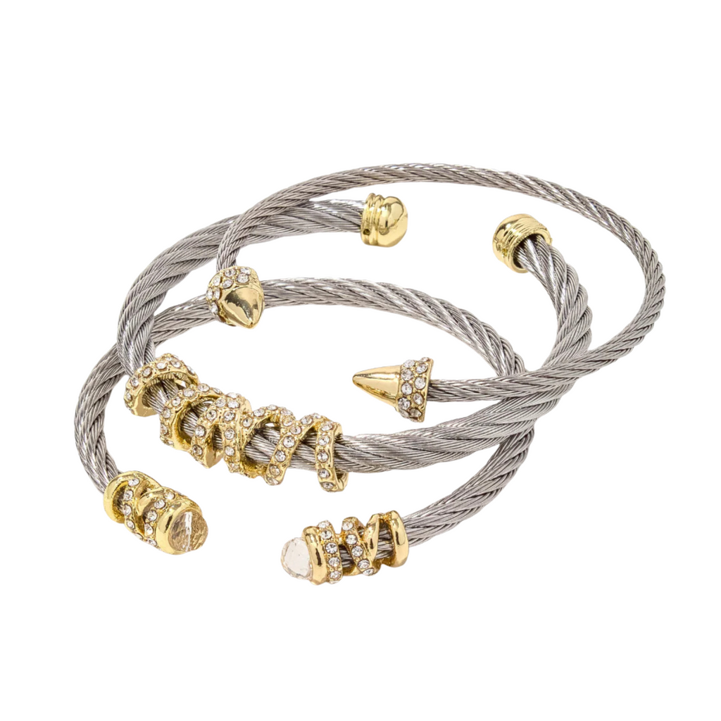 Gold and silver cable bracelet with decorative beads on a white background