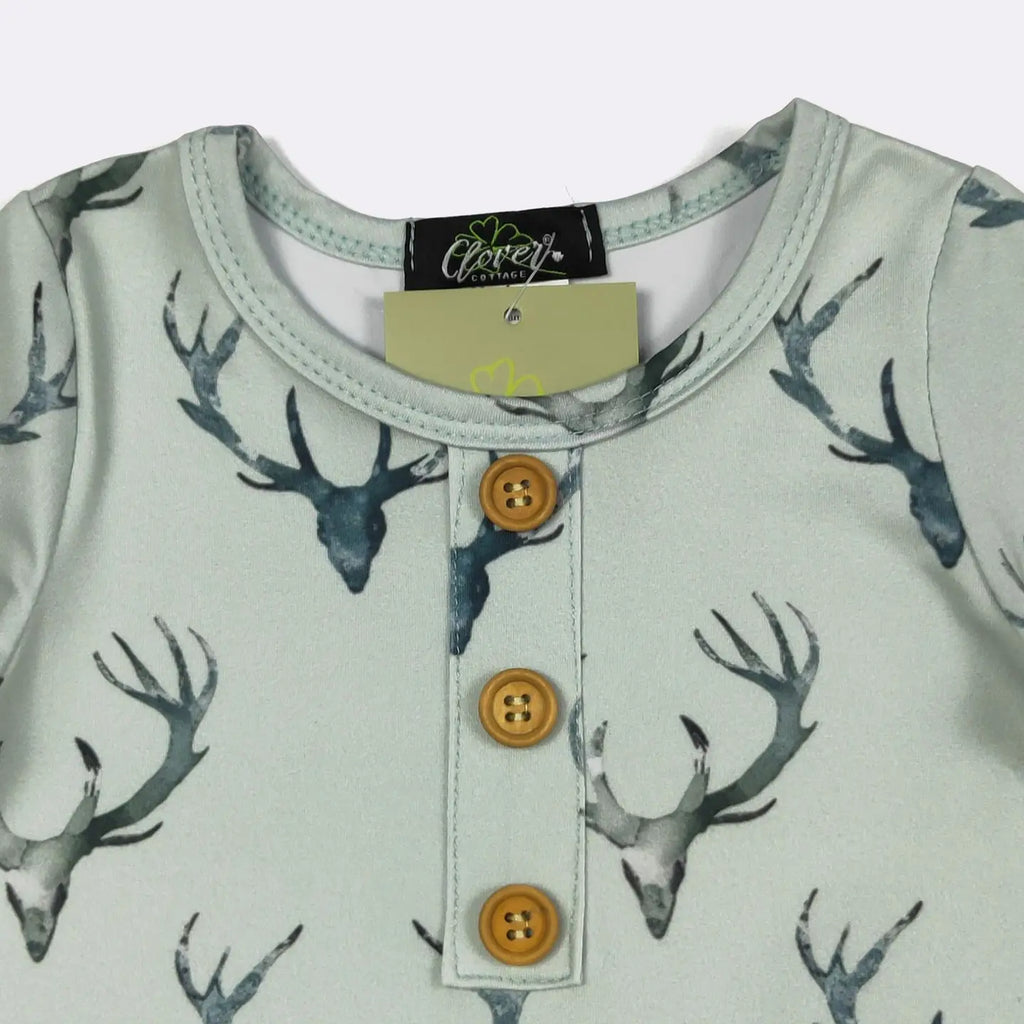 Children's shirt with deer antler pattern and button details, brand label visible.