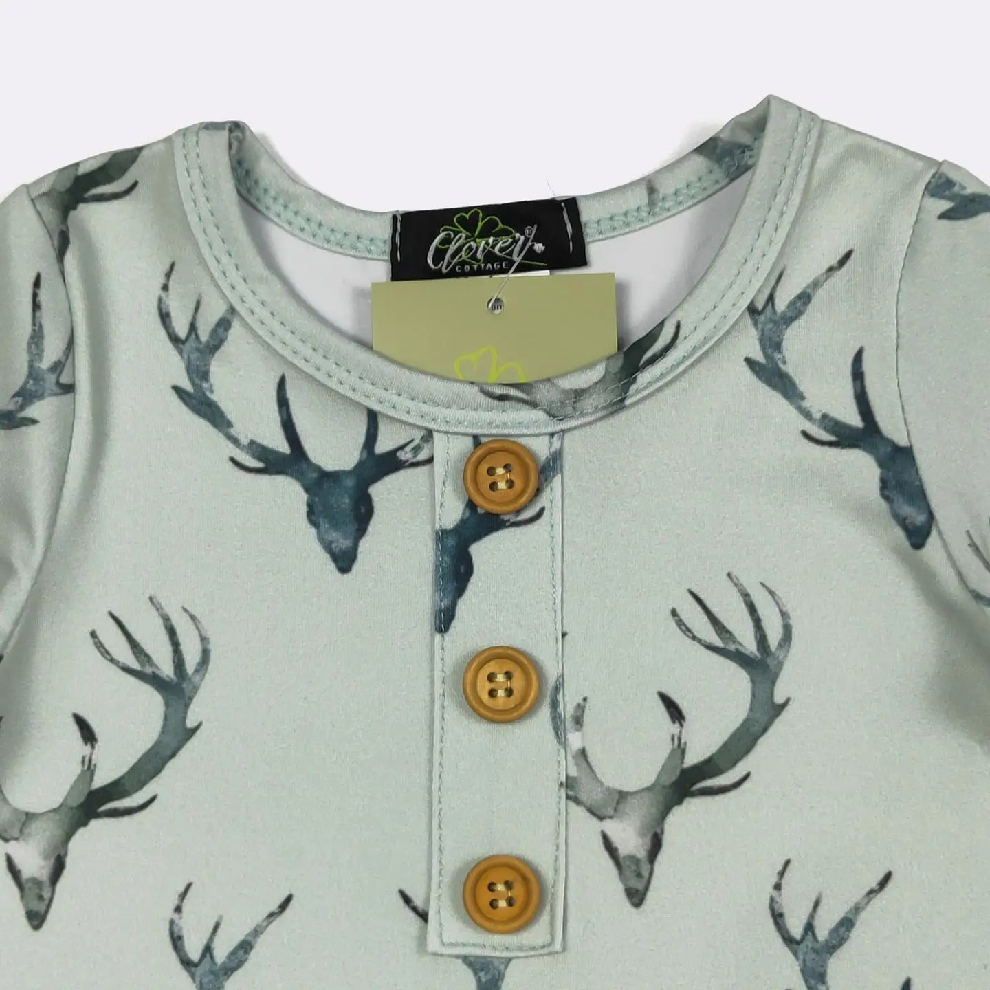 Children's shirt with deer antler pattern and button details, brand label visible.