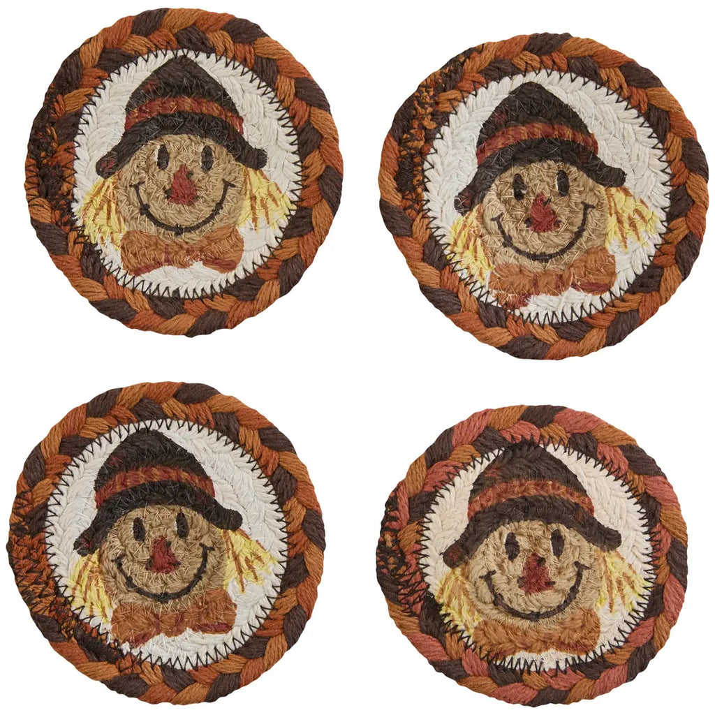 Four round coasters with scarecrow designs on a white background