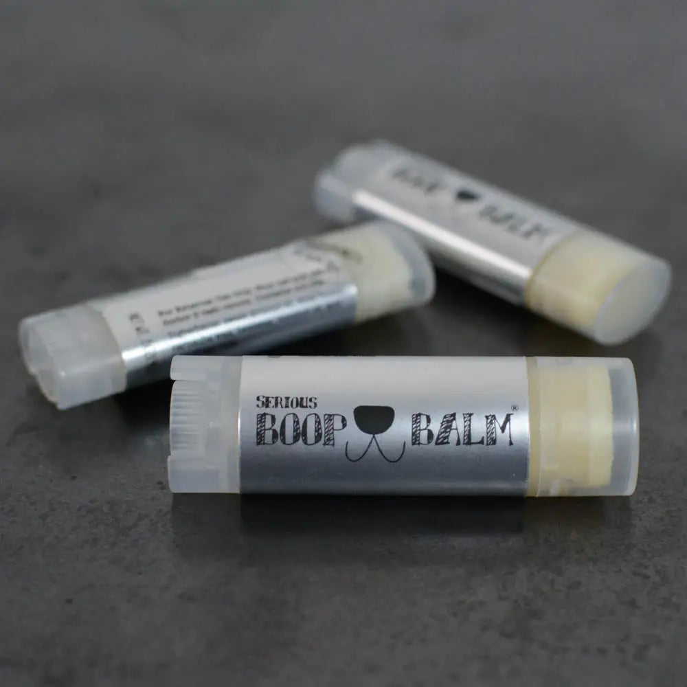 Three lip balm sticks on a dark surface with 'Serious Boop Balm' branding.