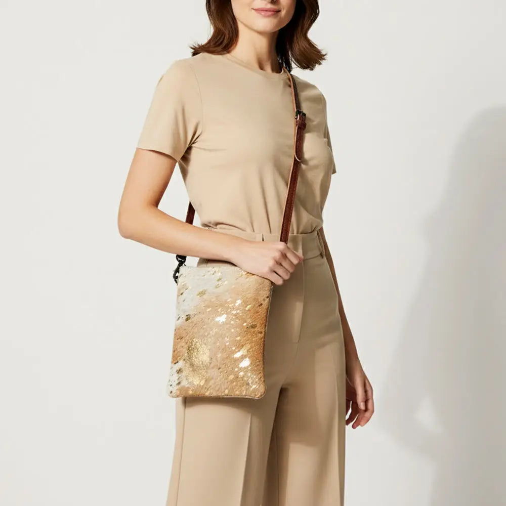 Woman holding a beige handbag with floral pattern against a white background