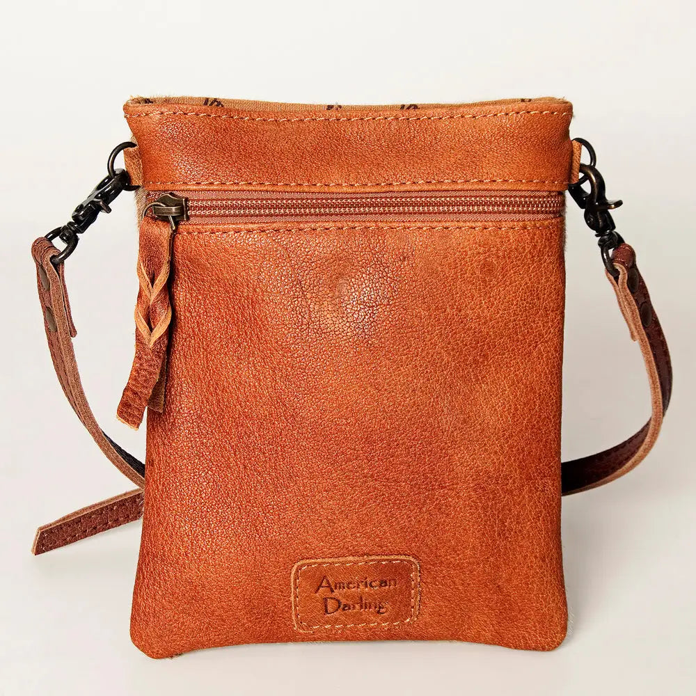 Brown leather crossbody bag with 'American Darling' branding on a light background