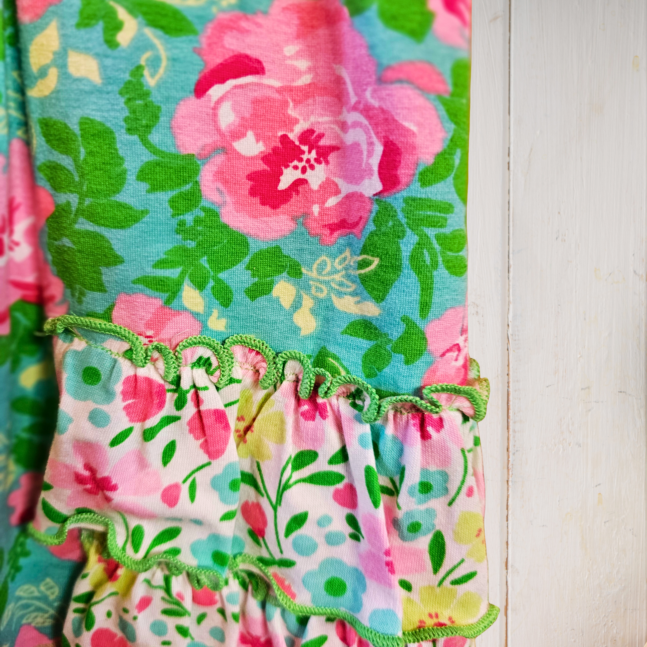Floral fabric with pink, green, and blue colors on a white background