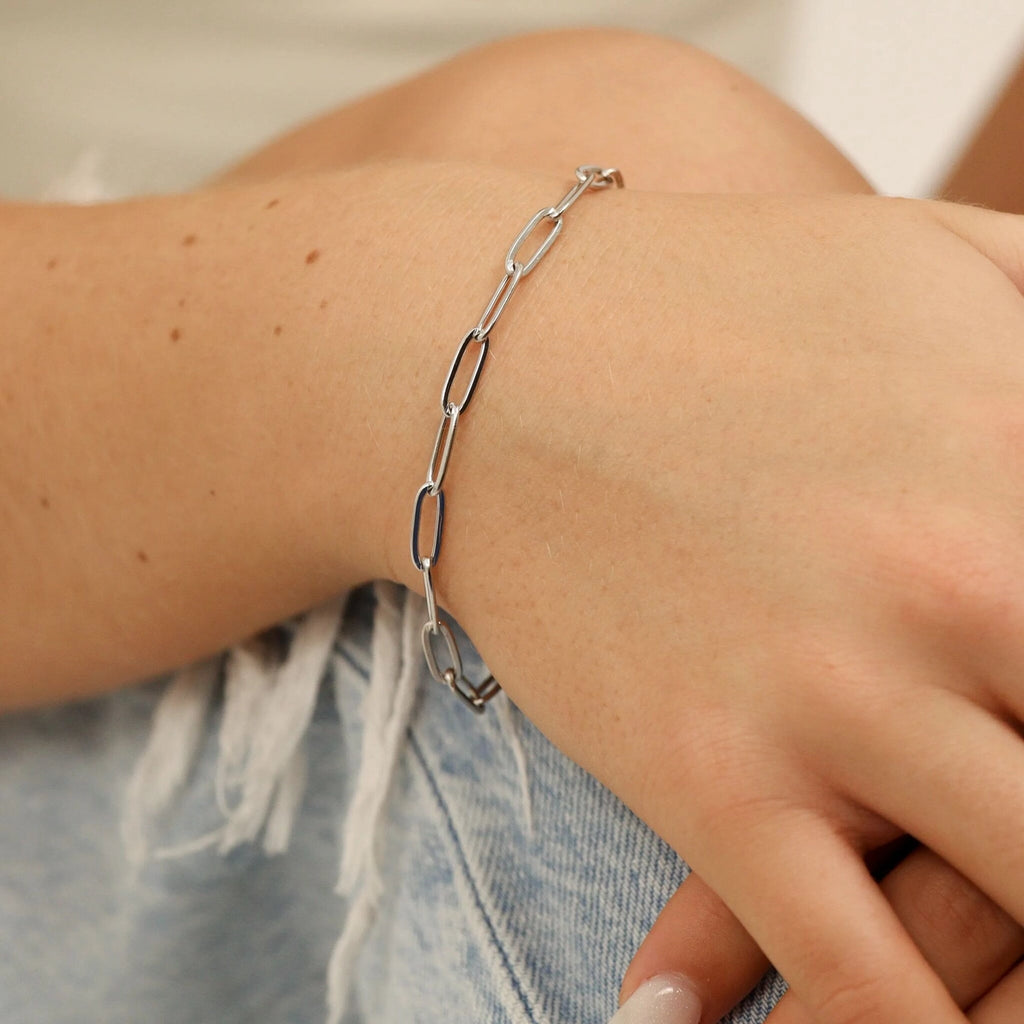 Silver chain bracelet on a wrist with a blurred background