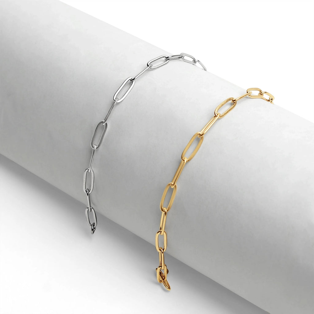 Gold and silver chain bracelets on a white surface