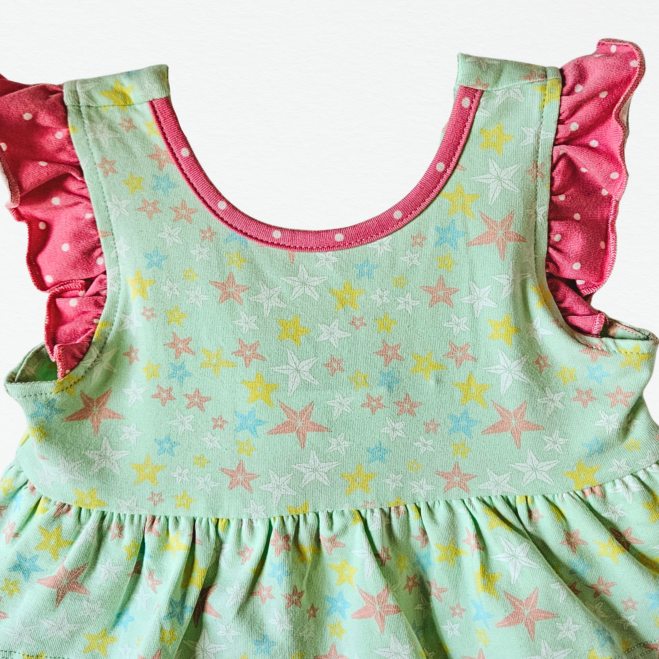 Children's bubble with star pattern and pink ruffled collar on a white background