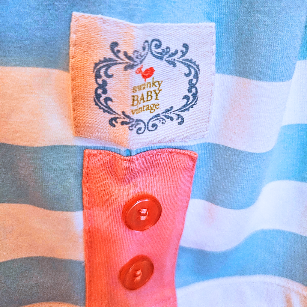 Close-up of a striped garment with a 'swanky BABY vintage' label.