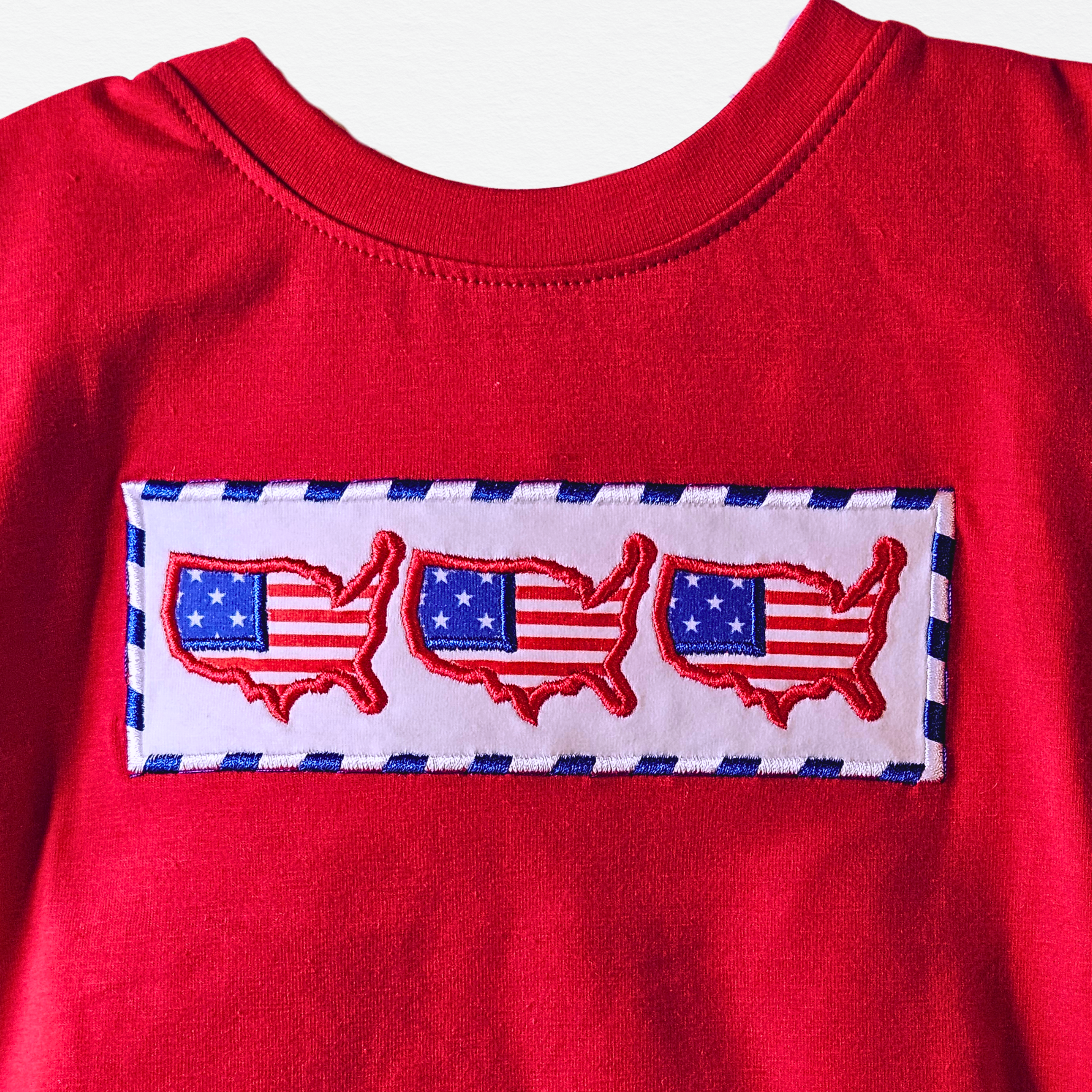 Red shirt with embroidered American flag design on a white background