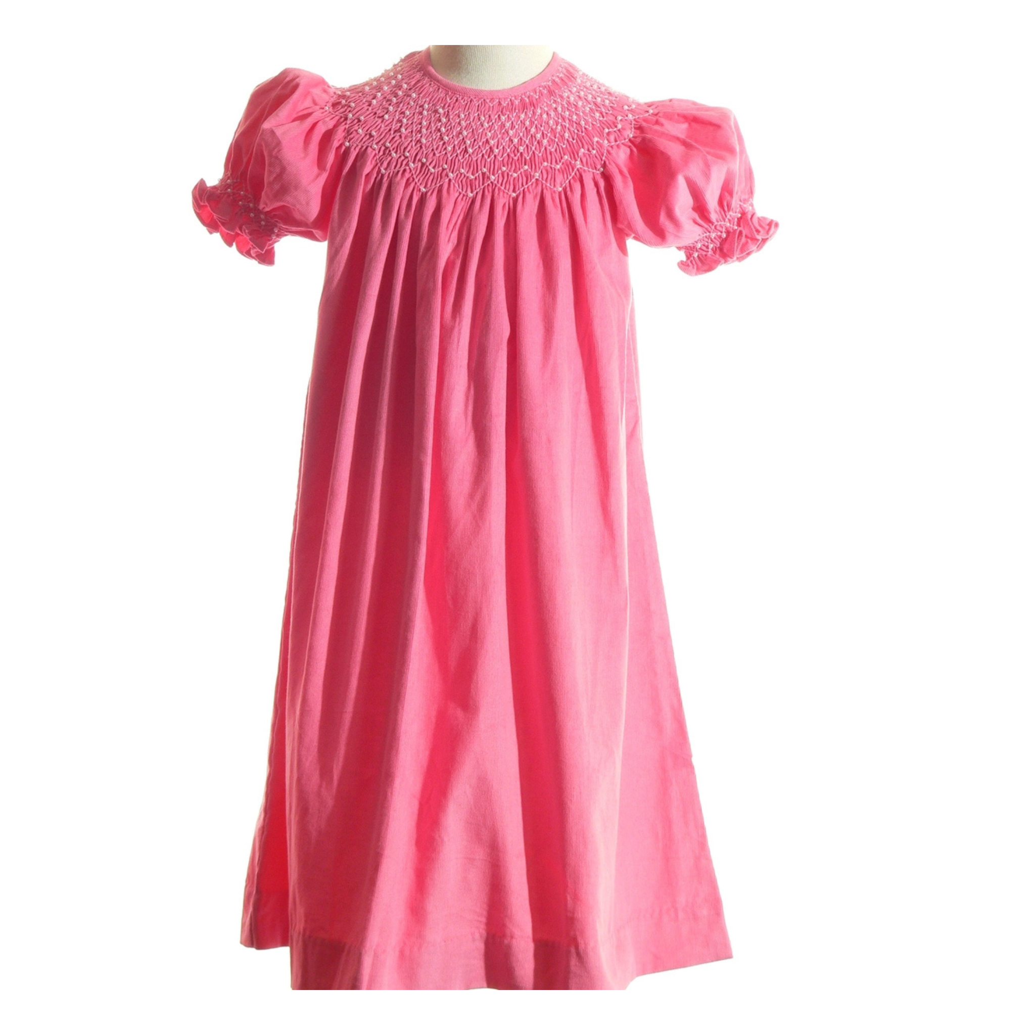 Pink dress with smocked bodice on a mannequin against a white background