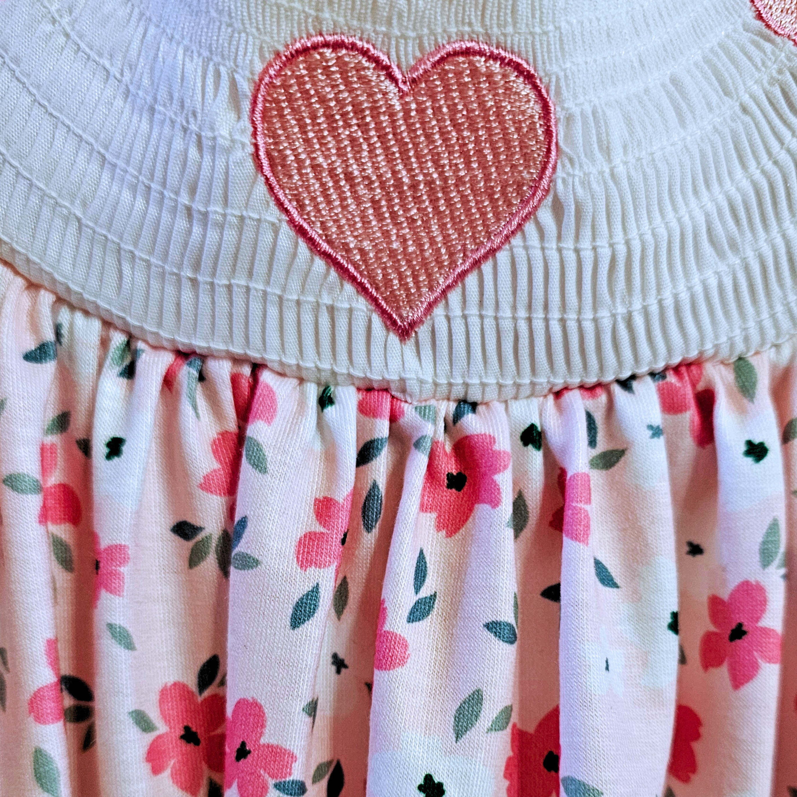 Close-up of a dress with a heart design and floral skirt