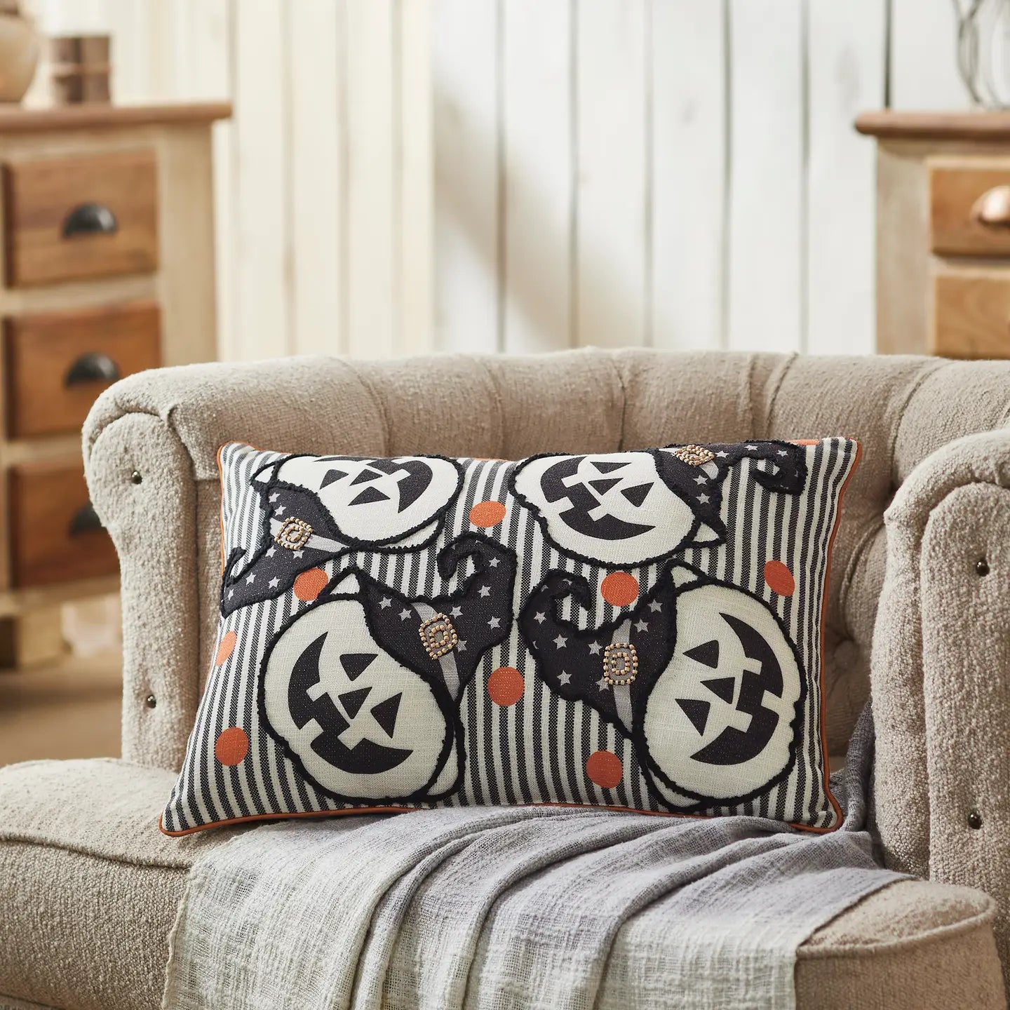 Decorative pillow with Halloween-themed design on a beige sofa