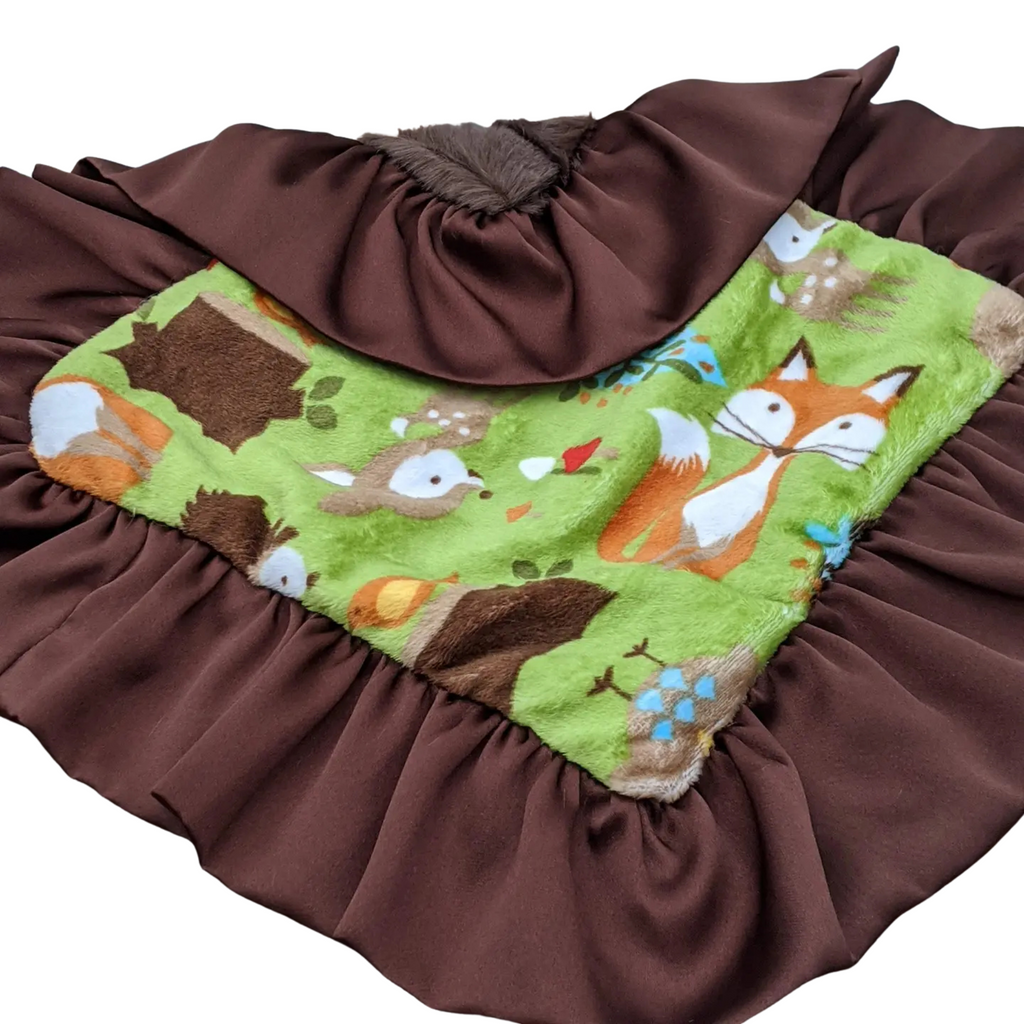 Baby blanket with fox and forest design on a brown background