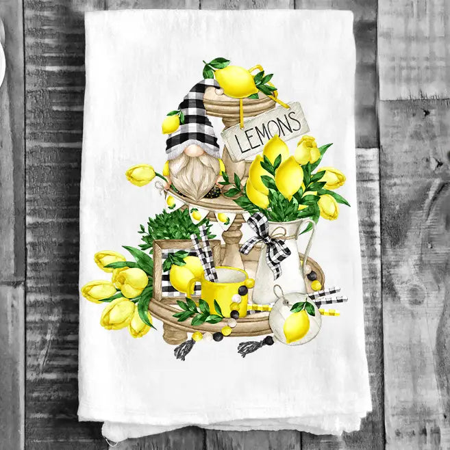 Tea towel with a design of lemons, gnomes, and a coffee cup on a wooden background