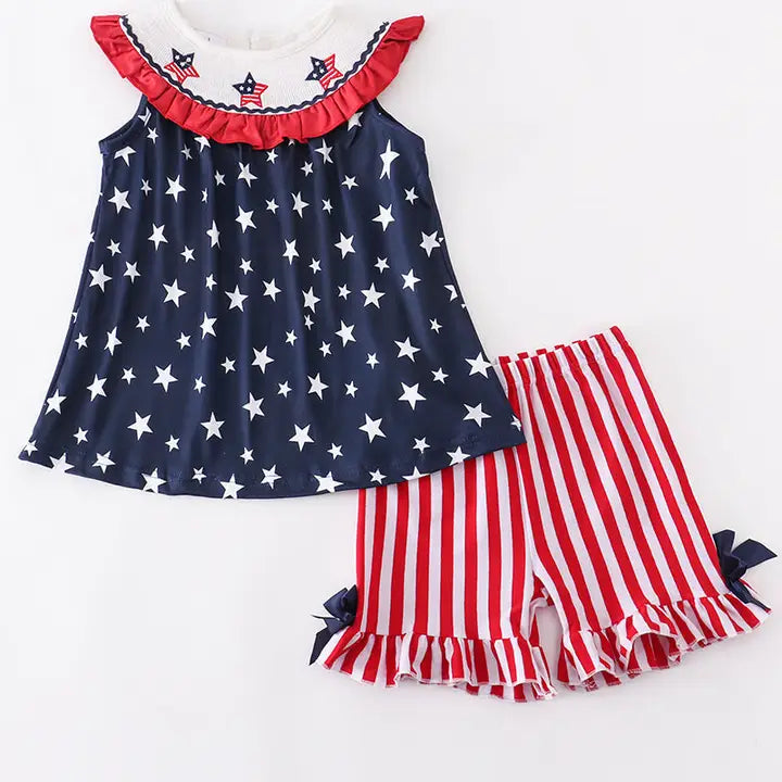 Children's outfit with star-patterned top and red, white, and blue shorts on a white background