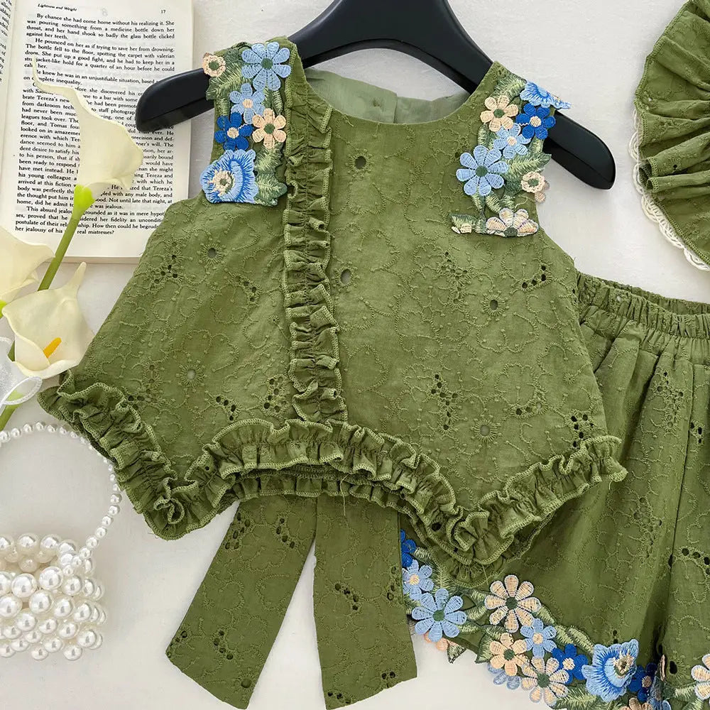 Green embroidered outfit with floral details on a white surface