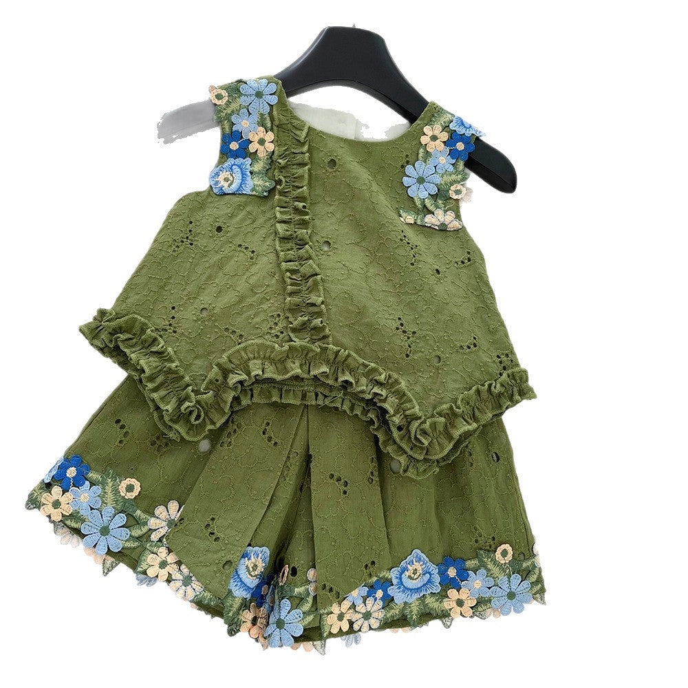 Green children's outfit with floral embroidery on a hanger against a white background