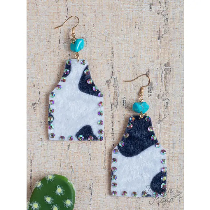 Pair of earrings with geometric design on a textured surface
