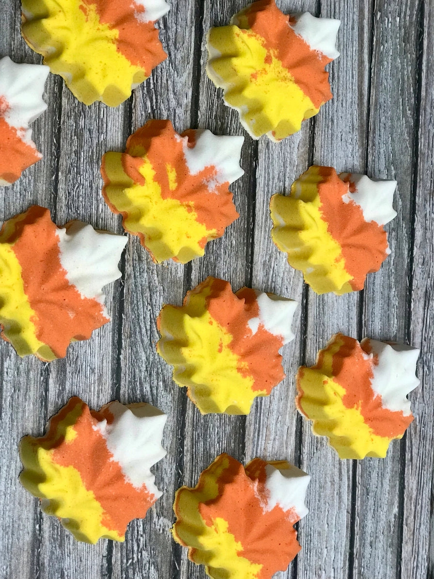 Colorful leaf-shaped bath bombs on a wooden surface