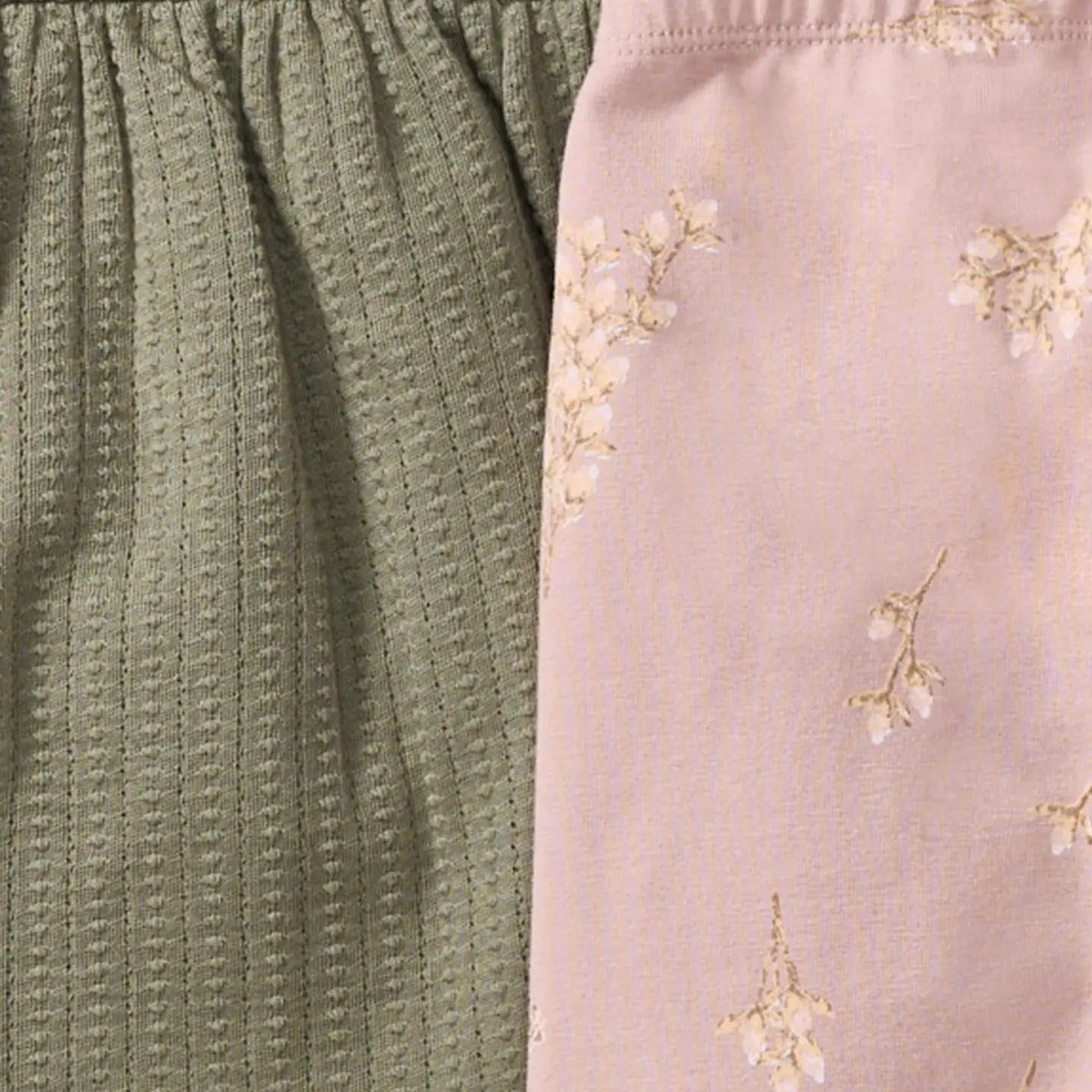 Close-up of textured green fabric and floral-patterned pink fabric.