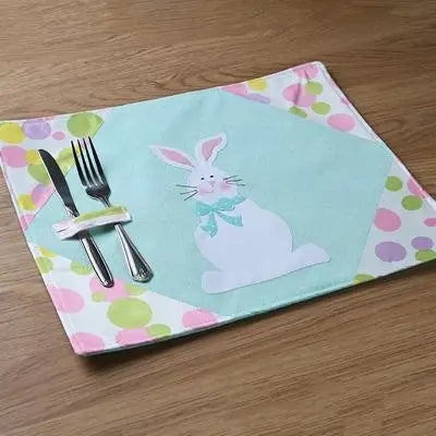 Placemat with bunny design and cutlery holder on a wooden surface