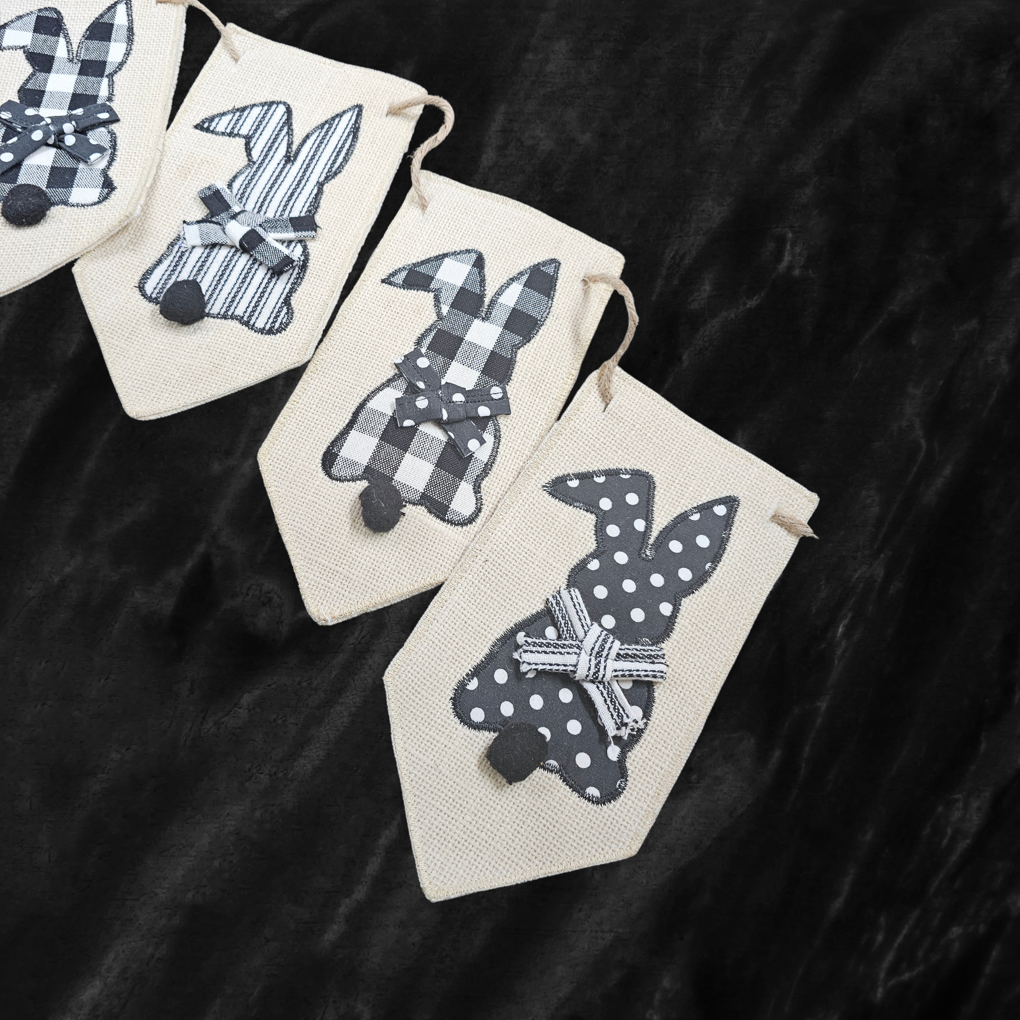 Decorative banner with black and white bunny designs on a textured black surface