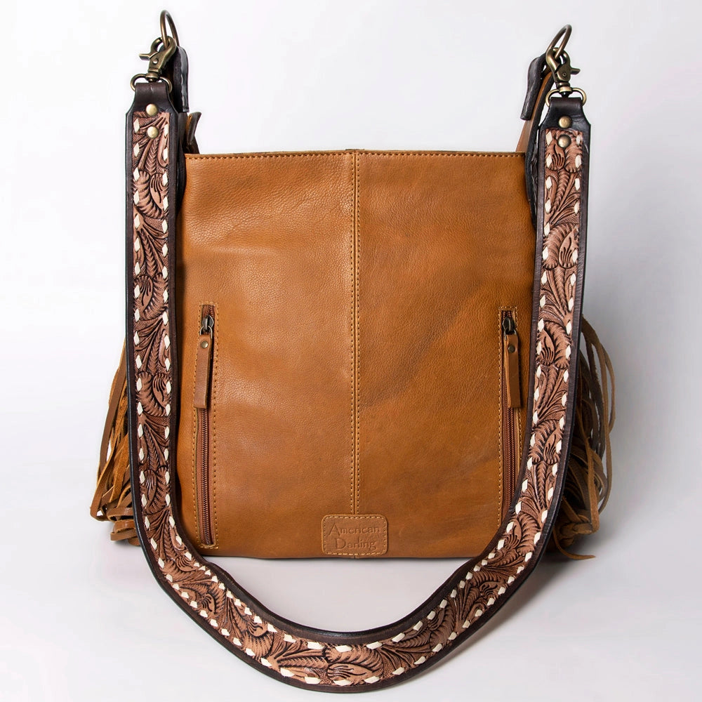 Brown leather handbag with intricate designs on a white background