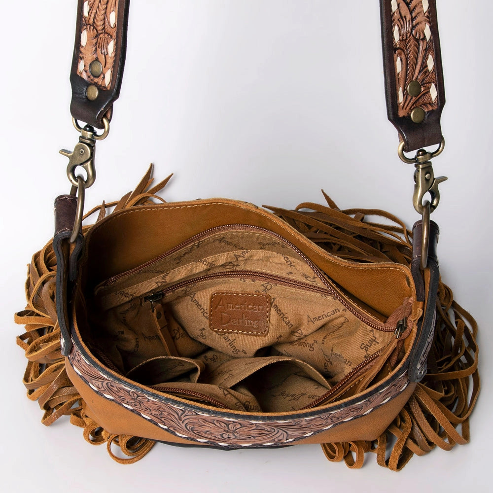 Brown leather handbag with intricate designs and fringes on a white background