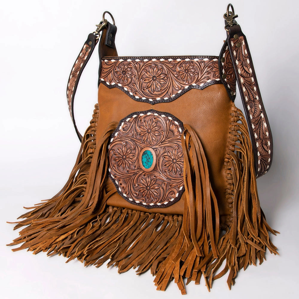 Brown leather handbag with intricate patterns and fringes on a white background